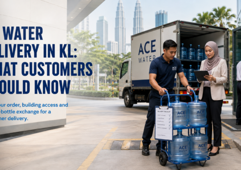 Ace Water staff delivering 19L RO water bottles to a customer at a commercial building in Kuala Lumpur, highlighting convenient RO water delivery, building access planning, and empty-bottle exchange.